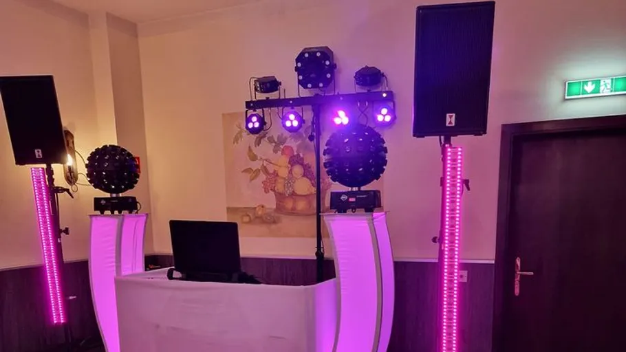 DJ setup with purple lights in a room.