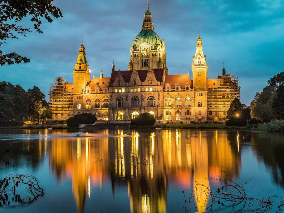 Historisches Gebäude reflektiert im Wasser während der Dämmerung.
