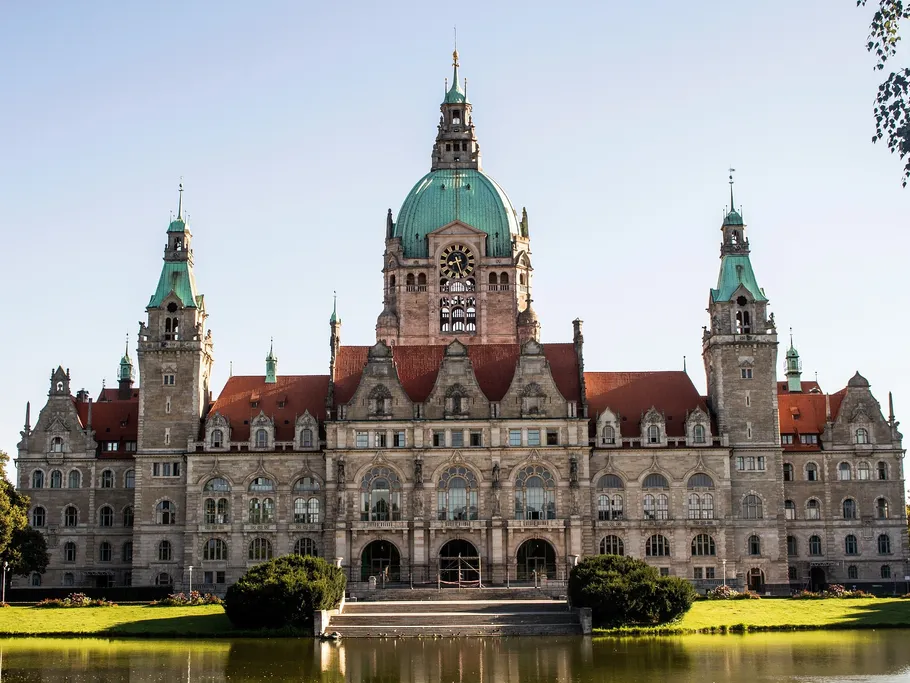 Historisches Gebäude spiegelt sich im Wasser eines Teiches.