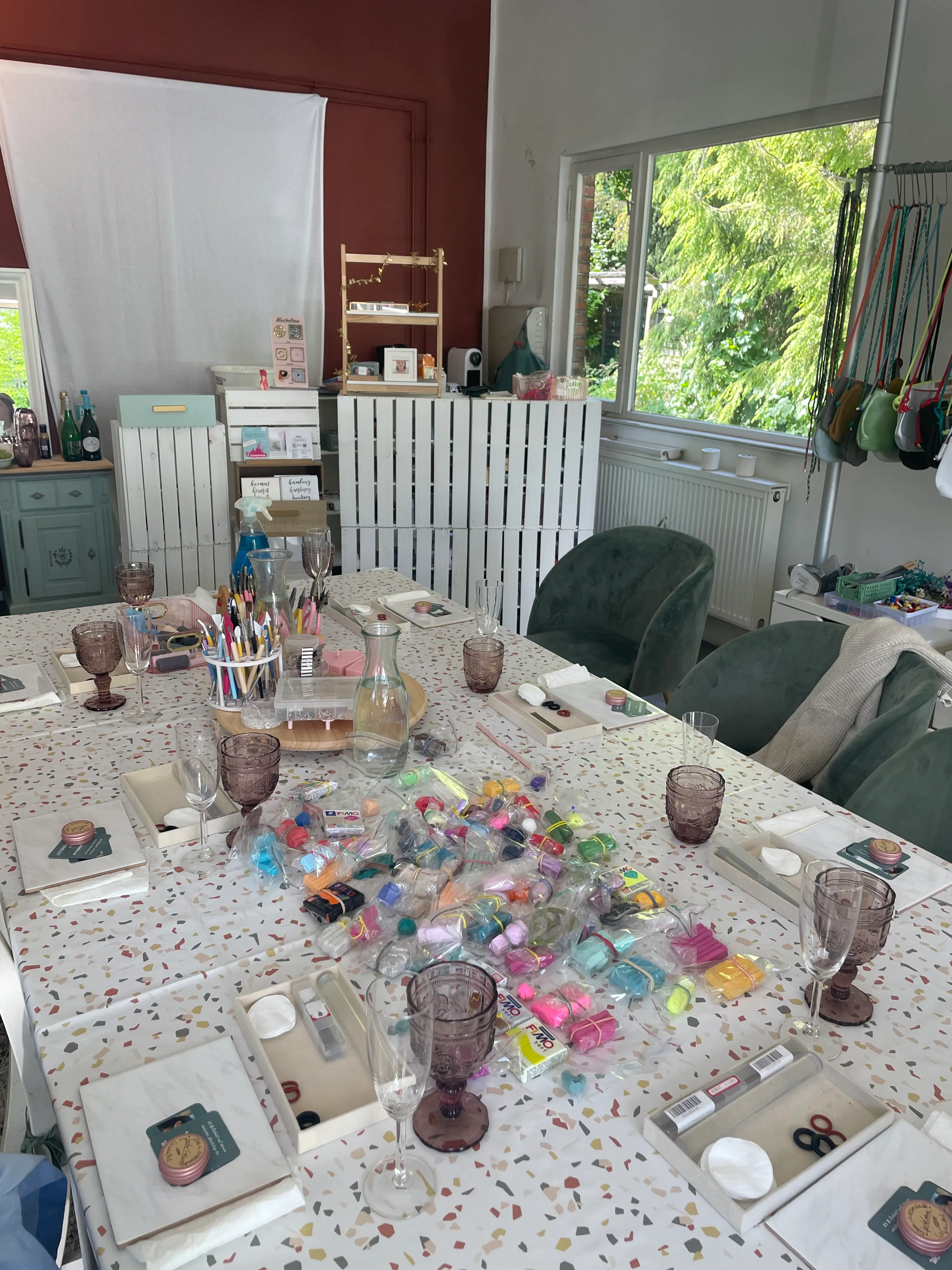 Craft table set with art supplies and glasses.