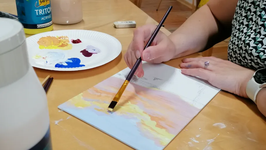 Person malt auf Leinwand mit Pinsel drinnen.
