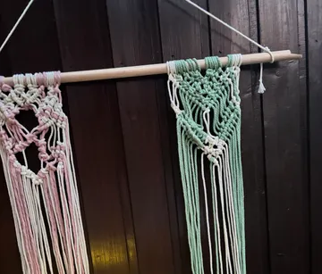 Macramé hanging with colorful patterns on wall.