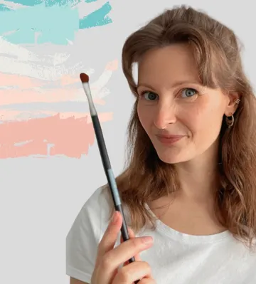 Woman holding paintbrush with abstract background.