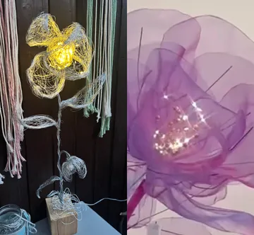 Wire flowers with lights in rustic setting.
