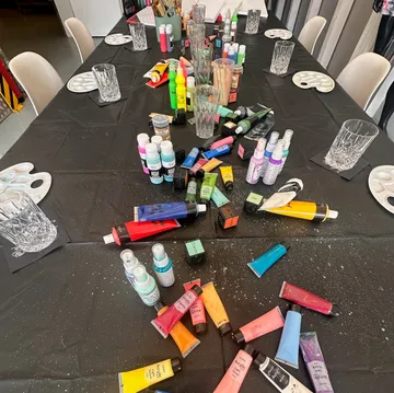 Art supplies scattered on black tablecloth.