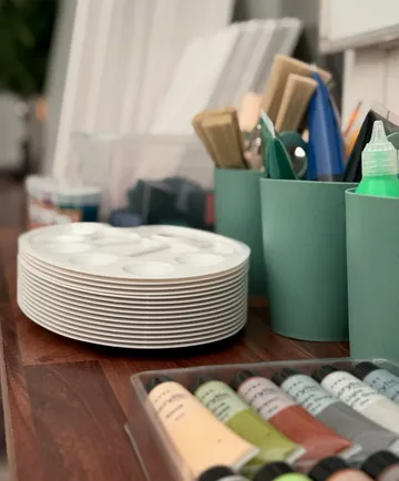 Art supplies organized on a wooden table.