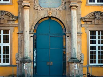 Blue gate opens to show a historic entrance.