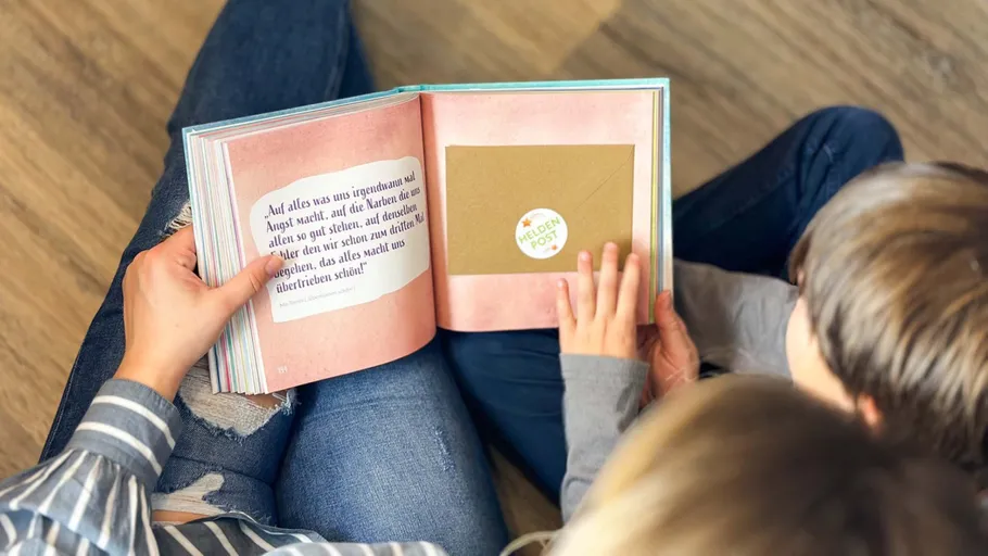 Adults reading a book with a child.