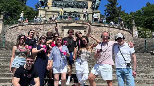 Group posing on stone steps outside monument.