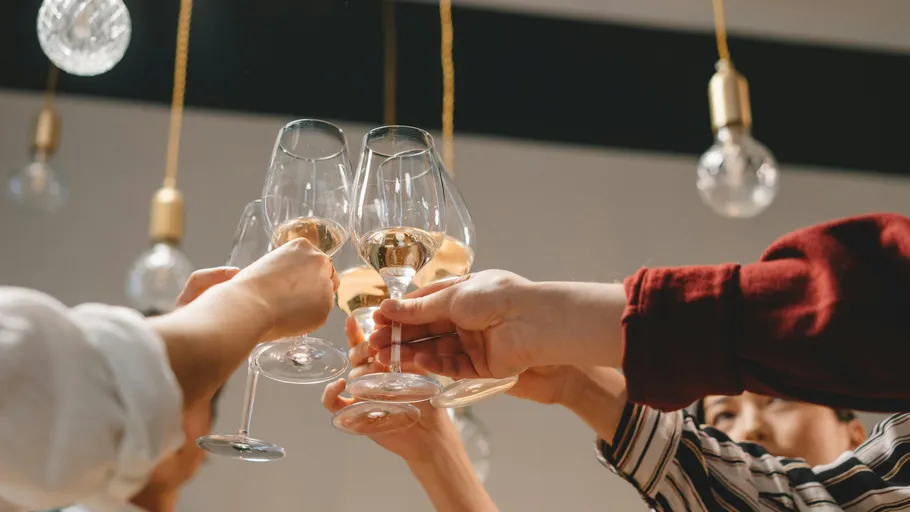 People clinking glasses during celebration indoors.