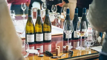 Several wine bottles and glasses on table.