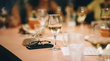 Wine glass on table in restaurant setting.