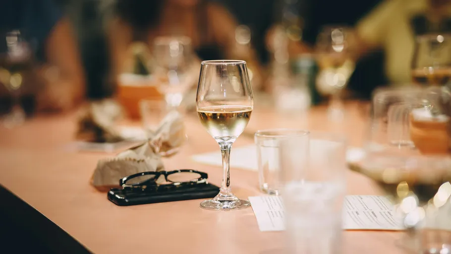 Wine glass on table in restaurant setting.