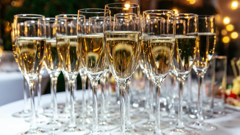 Champagne glasses filled on a banquet table.