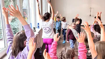 Kinder und Lehrerin machen Yoga im Klassenzimmer.