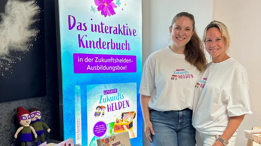 Two women stand beside interactive children's book display.