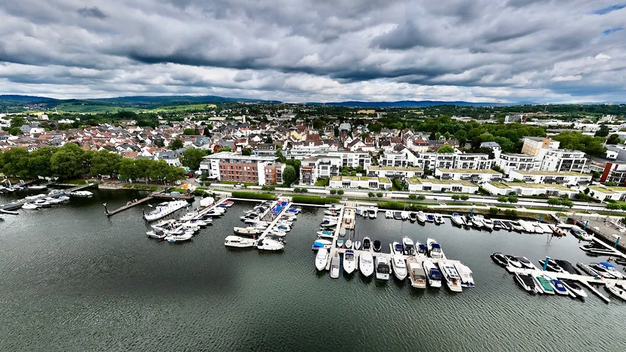 Boats docked in a marina cityscape cloudy sky.