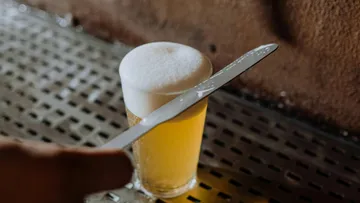 Beer glass foam skimmed with knife.