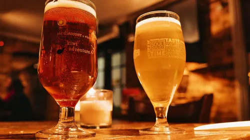 Two beer glasses on a wooden table.