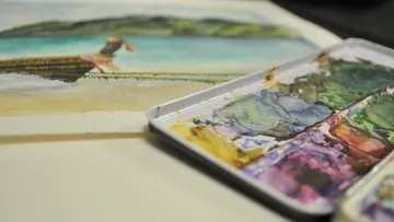 Aquarellgemälde neben Aquarellpalette.