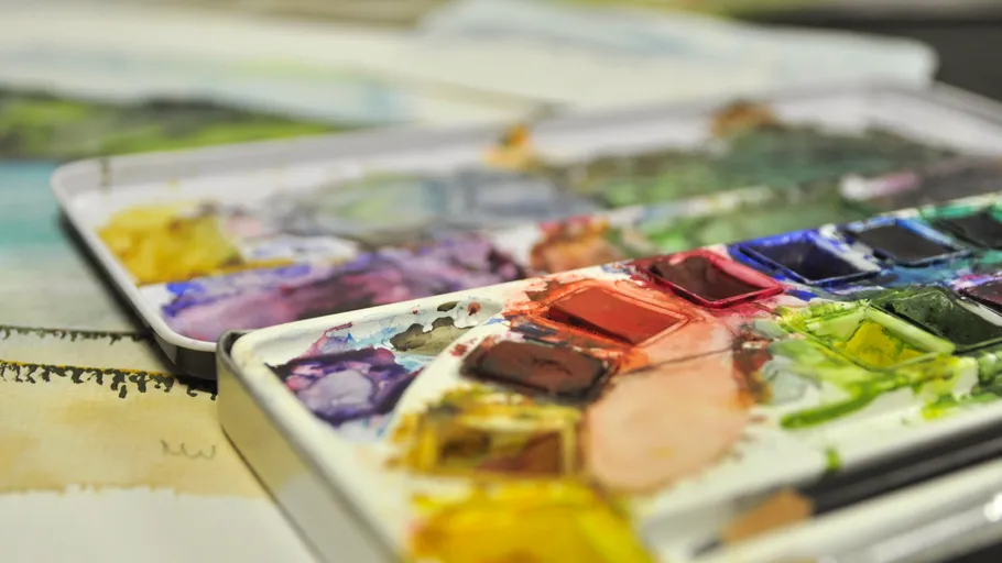 Open watercolor palette on an artistic table.