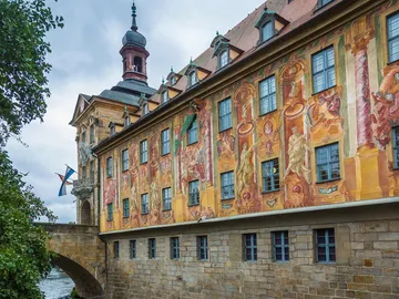 Frescoed wall of the historic building along a river.