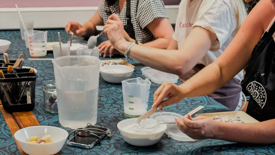 People crafting with materials on a table.
