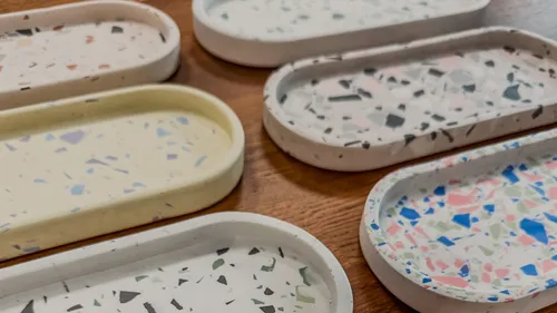 Bunte Terrazzo-Tabletts auf Holzoberfläche.