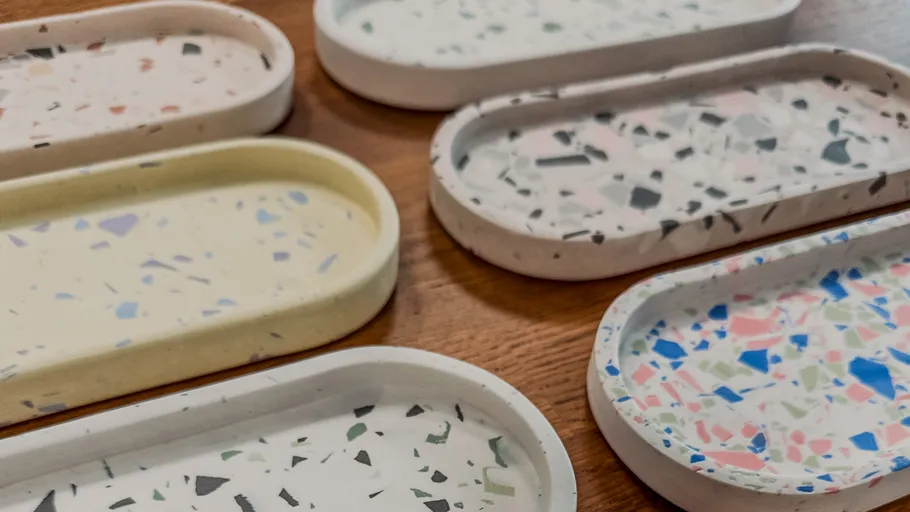 Bunte Terrazzo-Tabletts auf Holzoberfläche.