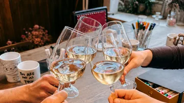 Four glasses clinking in a cozy setting.
