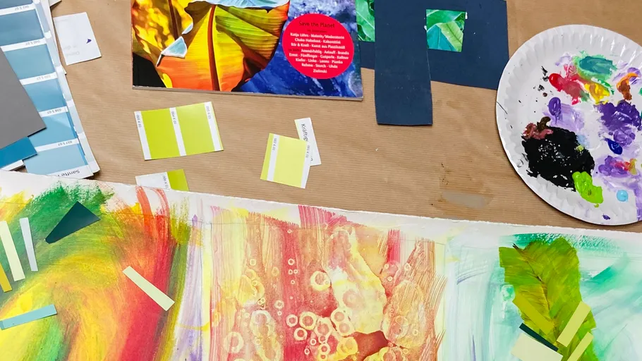 Art supplies and paintings on a table.