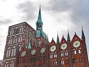 Medieval building with towers, under grey skies.