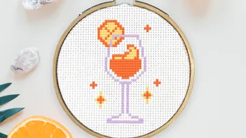 Cross-stitched drink with fruit in hoop.