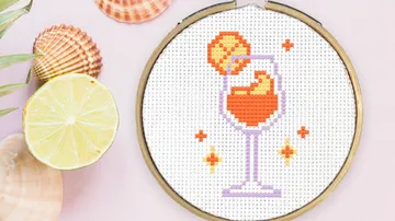 Cross-stitch of drink in hoop with lemon.