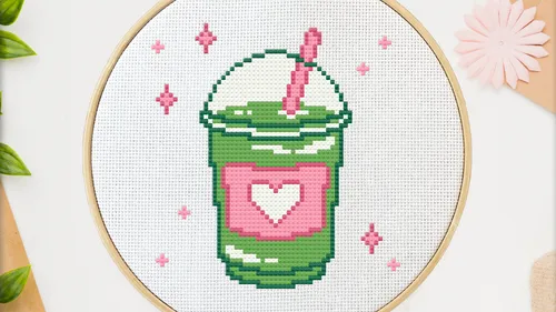 Cross-stitch of green drink with heart design.