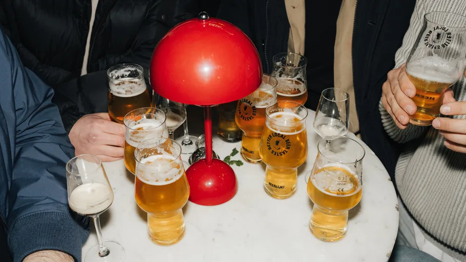Biergläser auf einem Tisch um eine rote Lampe.