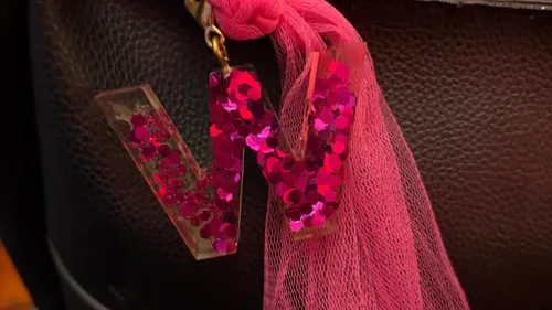 Letter 'W' keychain with glitter on bag.