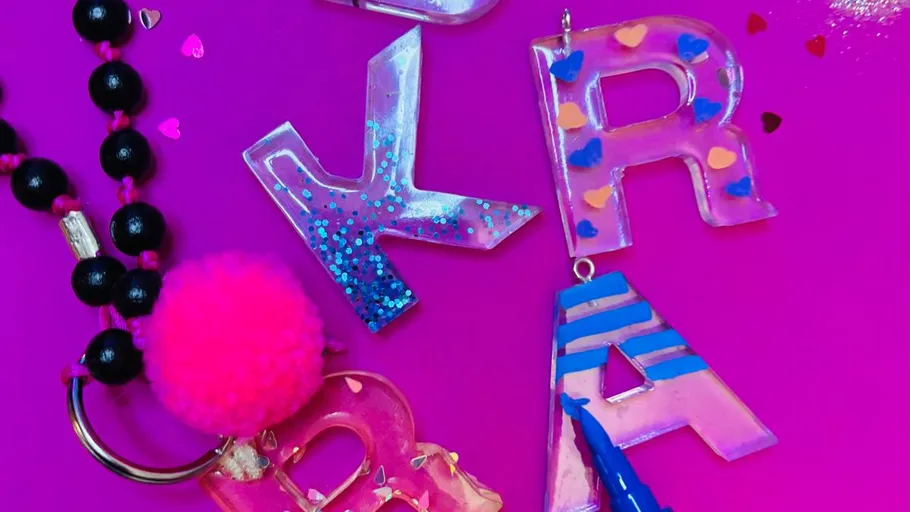 Colorful resin letters on pink background.