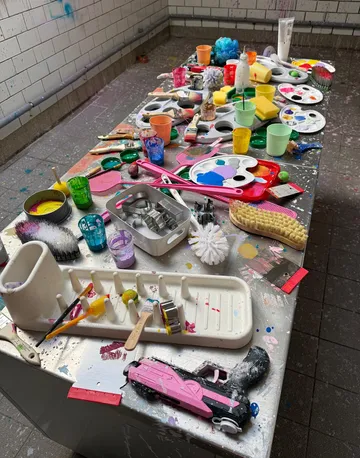 Messy table with art supplies in studio.