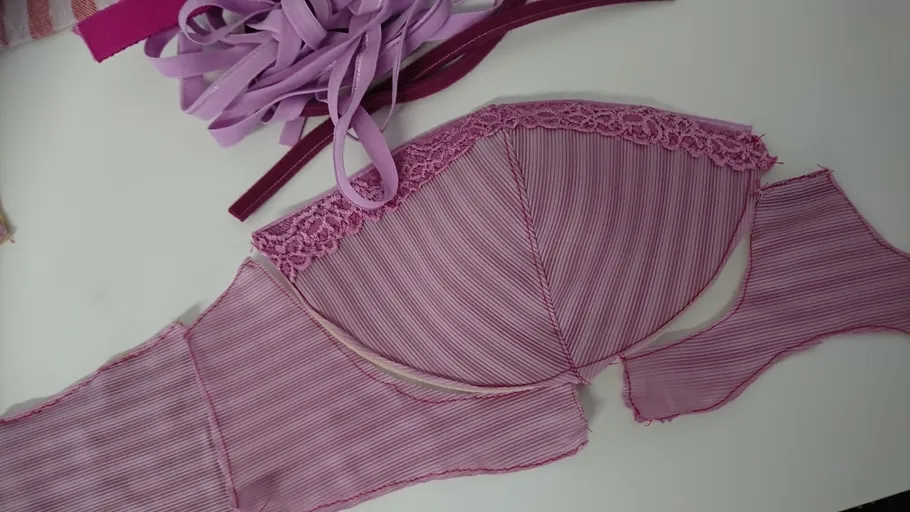 Pink bra in construction on white table.