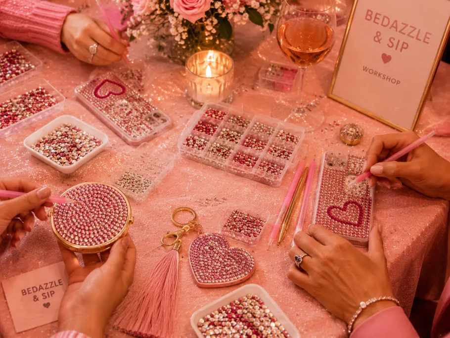 People bedazzling phone cases and accessories at workshop.