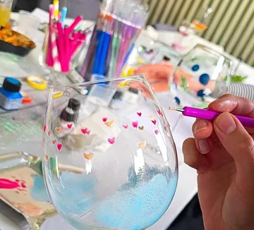 Hand painting wine glass with colorful designs.