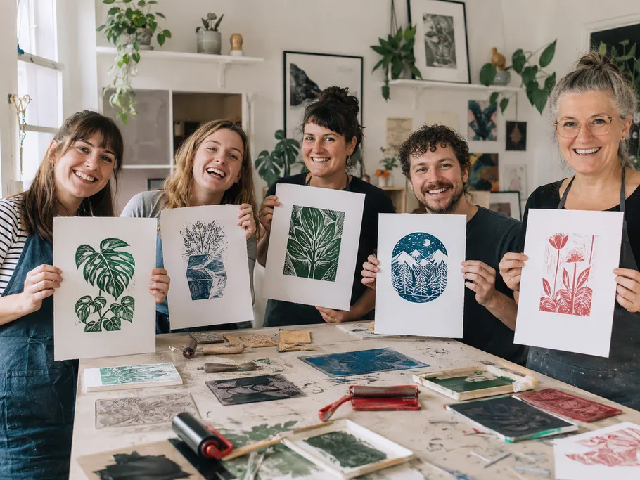 Gruppe hält Kunstwerke in einem kreativen Studio.
