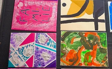 Four abstract paintings on display.