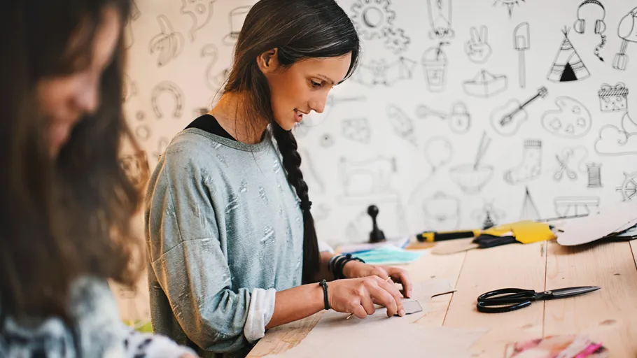 Woman crafting at a wooden table.