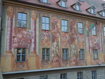 Façade with colorful pictures, windows frame the work of art.