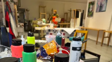 Farbflaschen auf Tisch im Kunststudio.