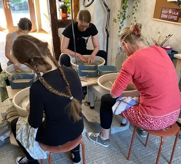 Drei Personen töpfern im Workshop.