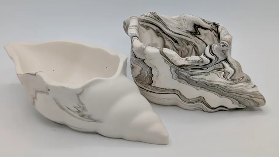 Zwei Keramikvasen in Muschelform auf weißem Hintergrund.