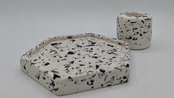 Terrazzo-Tablett und Becher auf weißem Hintergrund.